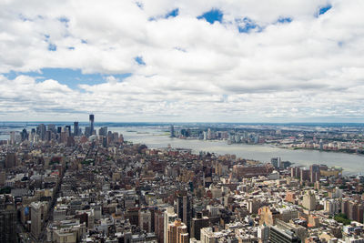 High angle view of city by sea against sky