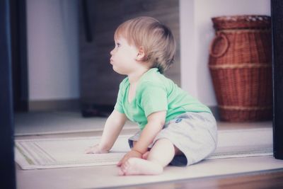 Side view of cute baby girl sitting at home