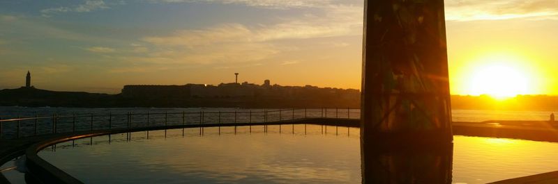 Pier on sea at sunset