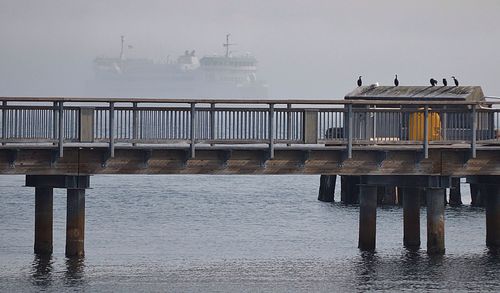 Pier on sea against sky in foggy weather