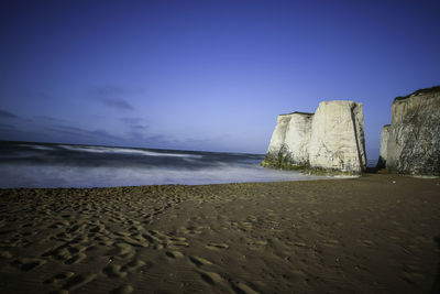 Scenic view of beach against blue sky