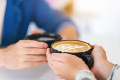 Midsection of man holding coffee cup