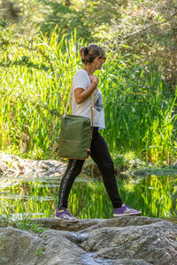 Side view of woman standing by plants