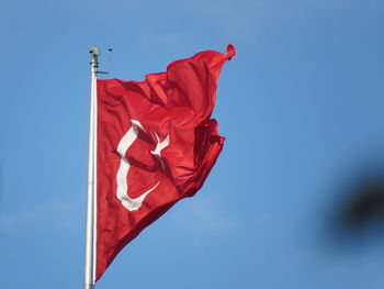 Low angle view of flag against blue sky