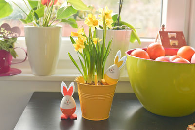 Close-up of easter eggs by potted plants on table at home