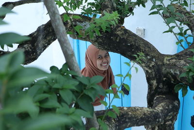 Low angle view of woman looking at tree