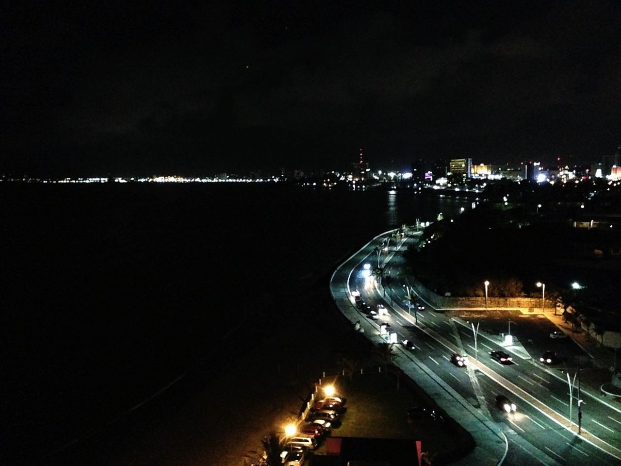 illuminated, night, transportation, mode of transport, city, high angle view, cityscape, land vehicle, architecture, car, built structure, building exterior, sky, city life, nautical vessel, travel, lighting equipment, road, street, copy space