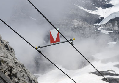 Low angle view of flag on snowcapped mountains against sky