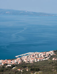 High angle view of townscape by sea against sky