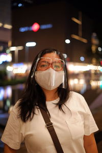 Portrait of young woman wearing face mask standing outdoors