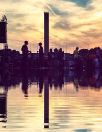 Reflection of people in water at sunset