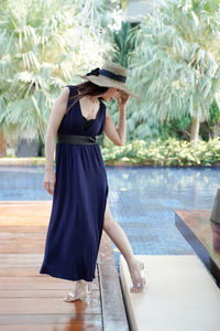 Full length portrait of beautiful woman in blue dress wearing a hat