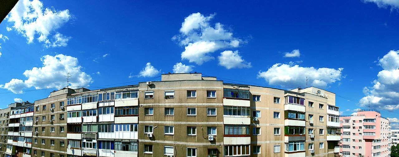 architecture, building exterior, built structure, sky, low angle view, window, blue, city, building, residential building, cloud, residential structure, cloud - sky, day, outdoors, sunlight, no people, apartment, modern, facade