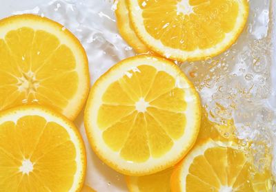 Slices of oranges in water on white background. oranges close-up in liquid with bubbles. 