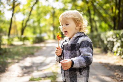 Portrait of boy blowing bubbles in park