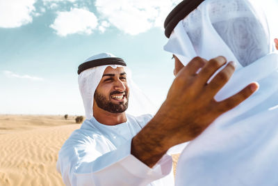 Portrait of smiling man standing against sky