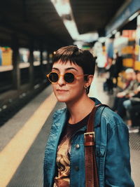 Portrait of young woman in sunglasses at subway station