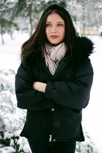 Portrait of young woman standing on snow