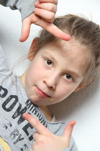 Close-up portrait of girl gesturing over white background
