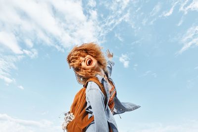 Low angle view of woman standing against sky