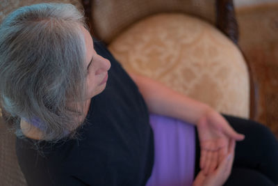 Midsection of woman sitting at home