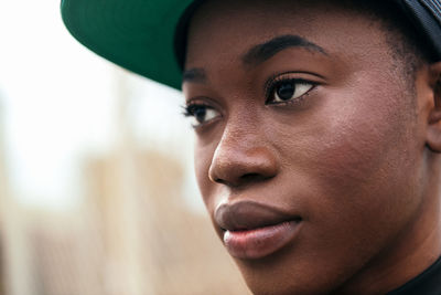 Young african american female in casual wear looking at camera with finger up in daylight