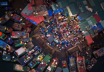 High angle view of market in town by moored boats in river