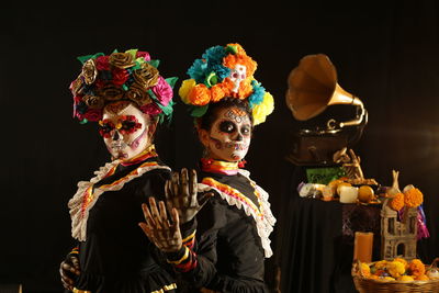 Females wearing costume against black background