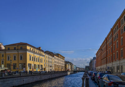 People in city against clear blue sky