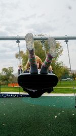 Low section of woman on swing in playground