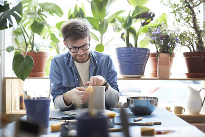 Young man shaping earthenware in pottery class