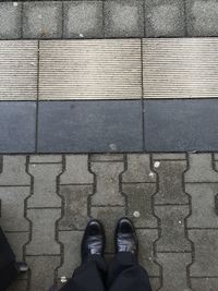 Low section of person standing on tiled floor