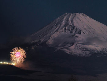Low angle view of snowcapped mountain against sky at night