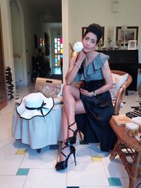 Young woman sitting on chair at home