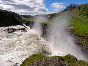 Scenic view of waterfall against sky