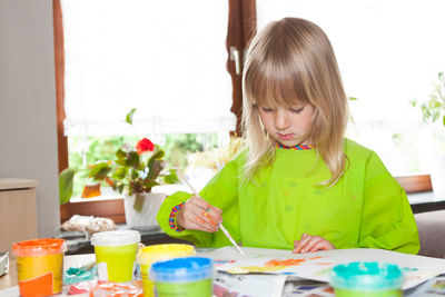 Cute girl sitting on table at home