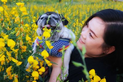 Close-up of cute dog with women amidst plants