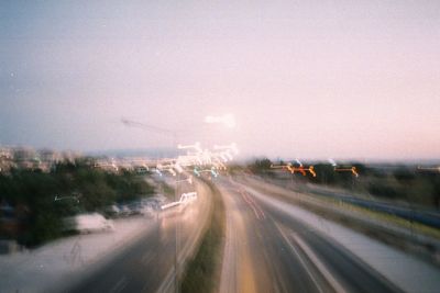 Cars on road in city against sky