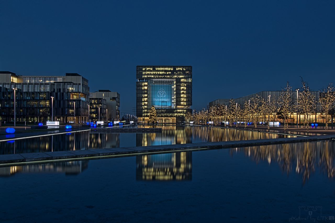 reflection, architecture, illuminated, building exterior, city, night, water, modern, skyscraper, built structure, cityscape, no people, clear sky, waterfront, bridge - man made structure, travel destinations, sky, outdoors