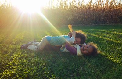 Side view of young woman resting on grassy field