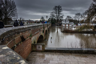 Arch bridge over river against cloudy sky at stratford-upon-avon