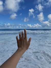 Midsection of person on sea against sky