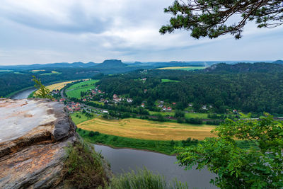 Scenic view of river by mountains against sky