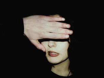 Close-up of woman hand against black background