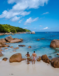 People at beach against sky