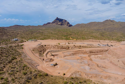 Scenic view of desert against cloudy sky