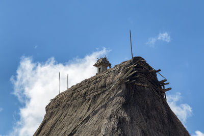 Low angle view of bird on wooden post against sky