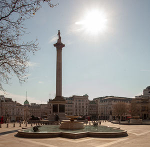Statue in city against sky