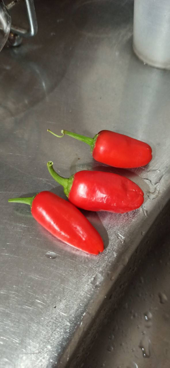 CLOSE-UP OF RED CHILI PEPPERS AND TOMATOES ON TABLE