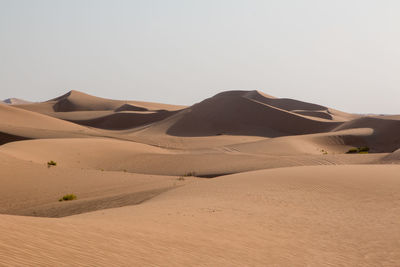 Sand dune in desert against clear sky